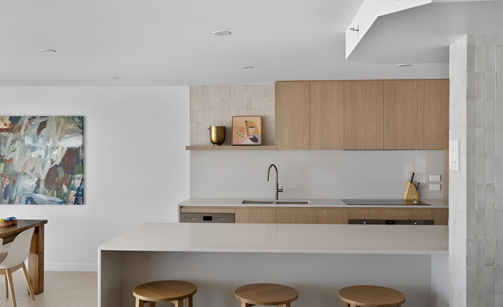 A Kitchen With Wooden Cabinets, a Sink, a Table and Stools — CK Cabinetry in Coolum Beach, QLD