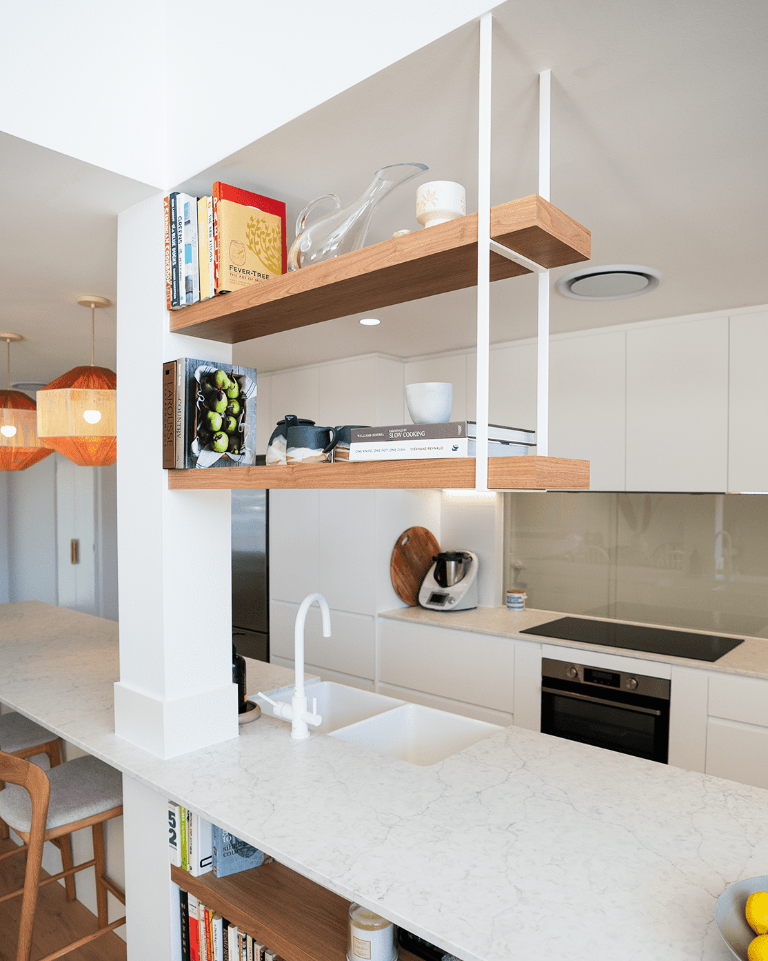 Modern kitchen with white counters, wooden shelves holding books and dishes, and a sink — CK Cabinetry in Coolum Beach, QLD