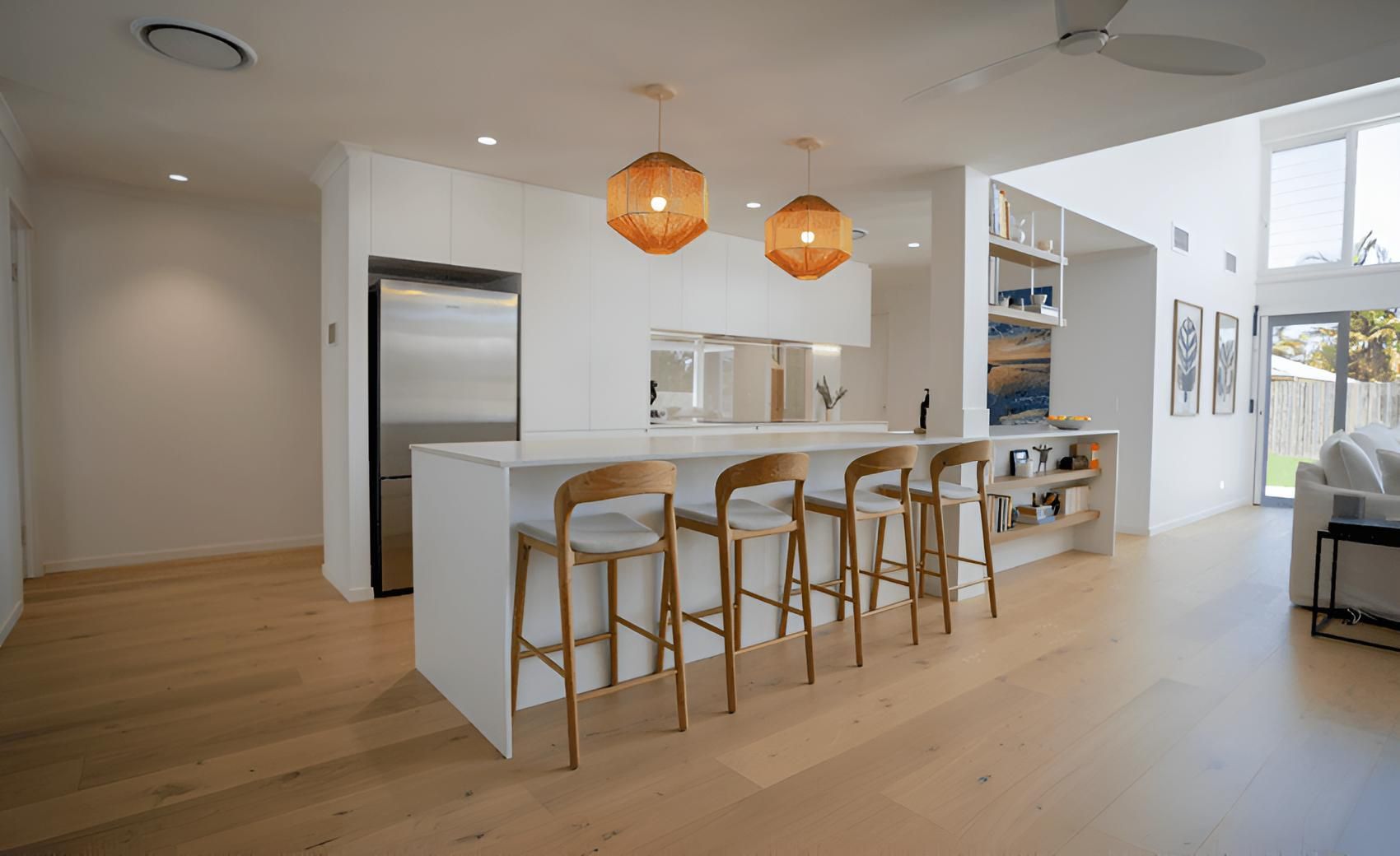 A Kitchen With a Long Island and Stools in a House — CK Cabinetry in Coolum Beach, QLD