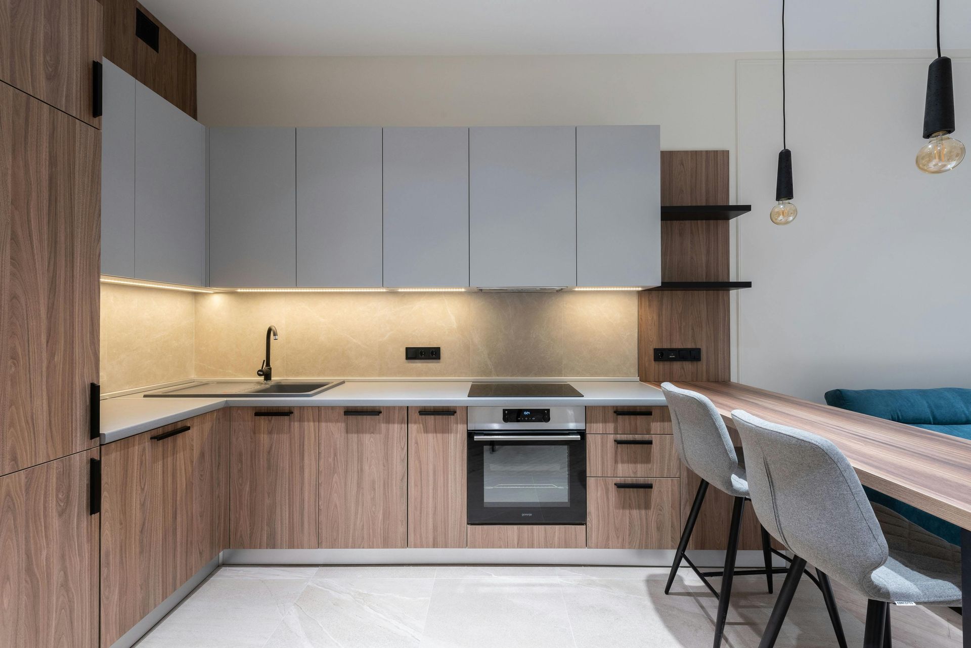 Modern kitchen with wood cabinets, white upper cabinets, black accents, and a dining area with chairs