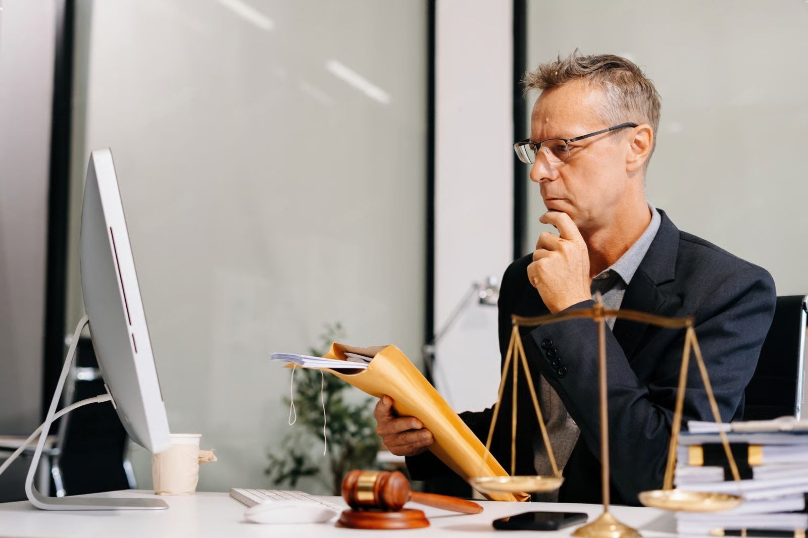 Person filling out tax form 1040, holding pen, palm leaf in background.