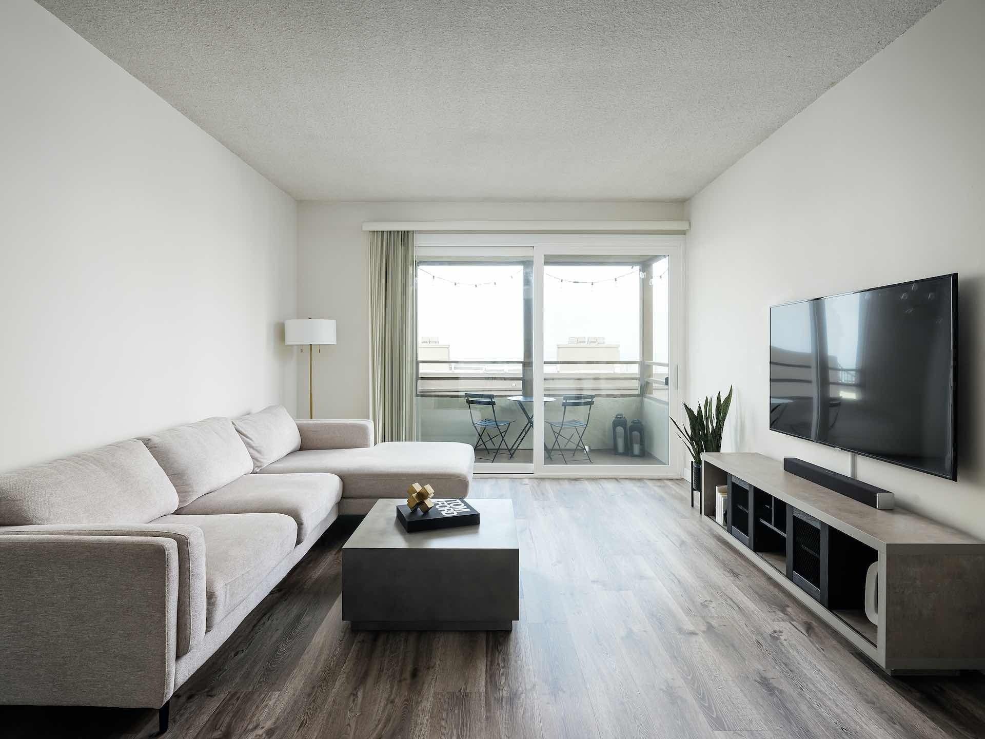 Hardwood floor living room with glass sliding door leading to balcony