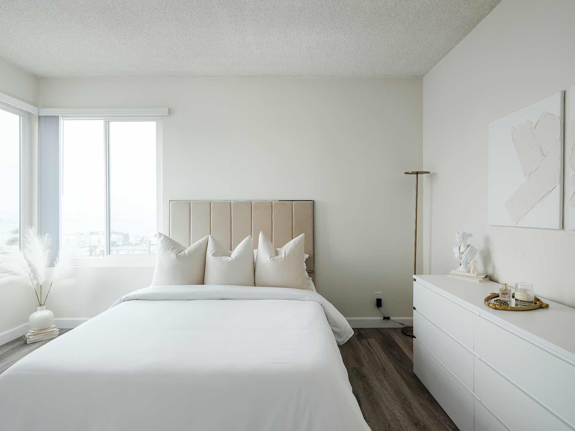Furnished bedroom with window and white walls