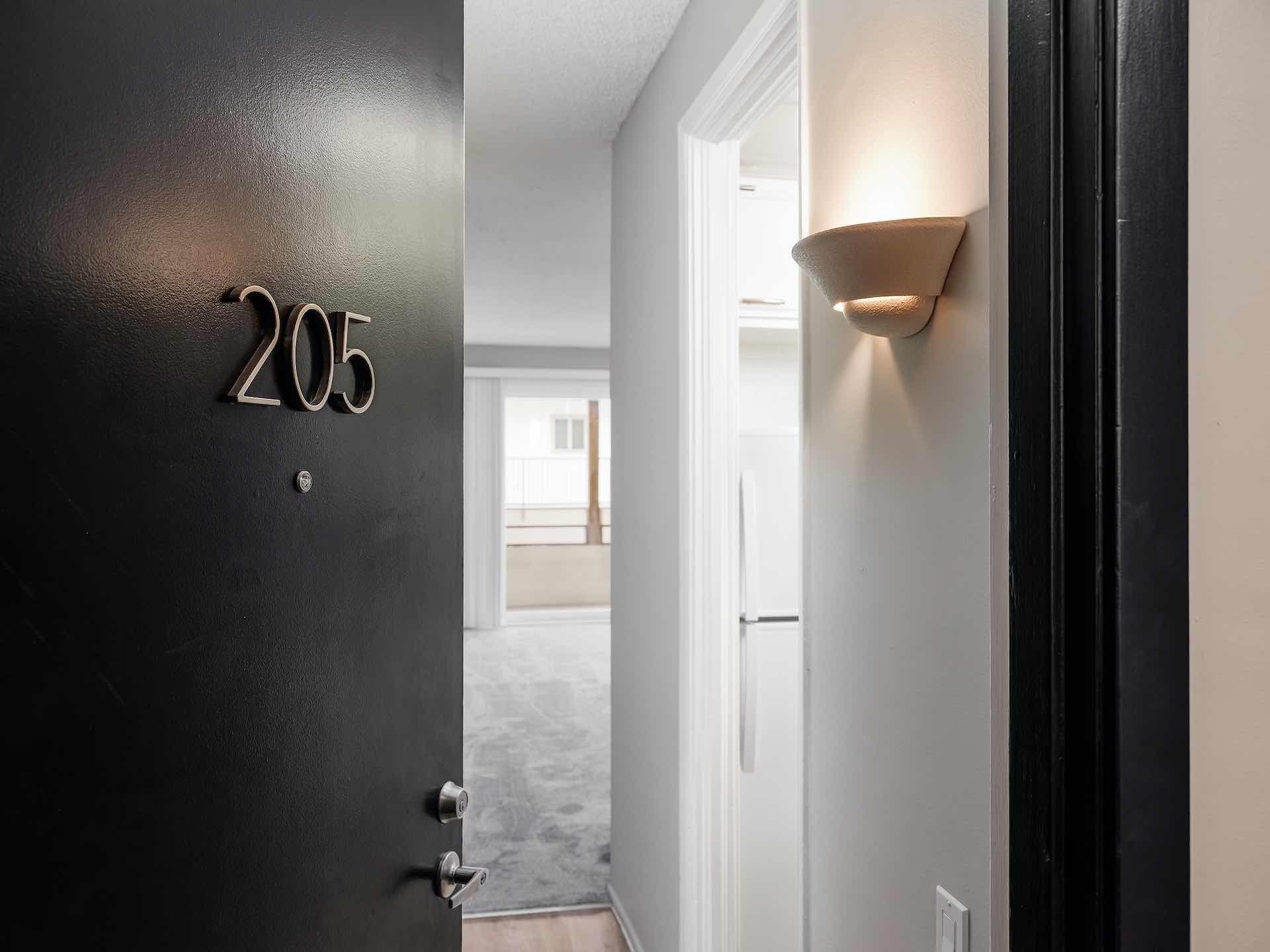 Entryway to apartment unit with brass light fixture
