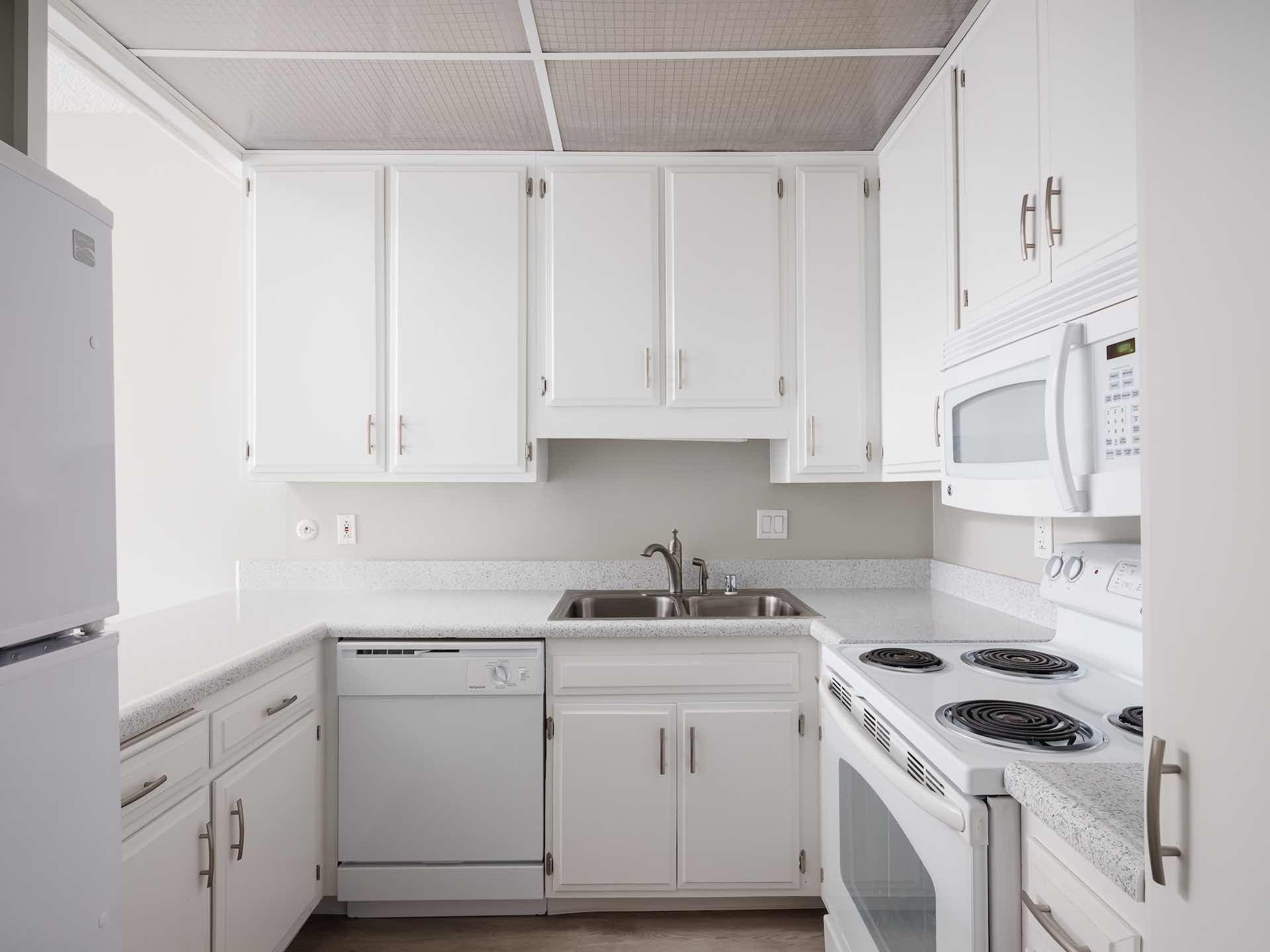 Kitchen with white cabinetry and full appliances