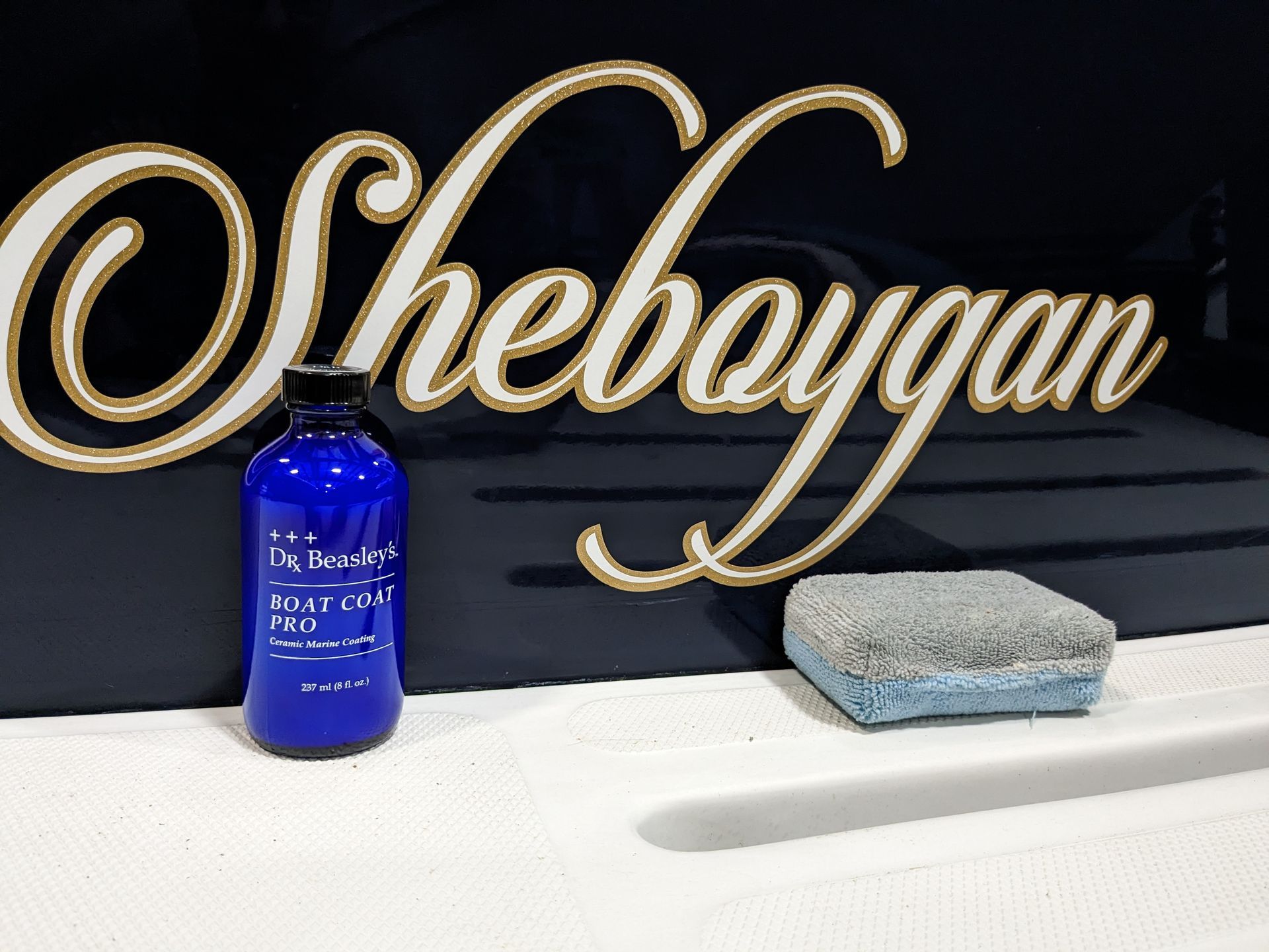 A bottle of sheboygan sits on a counter next to a sponge
