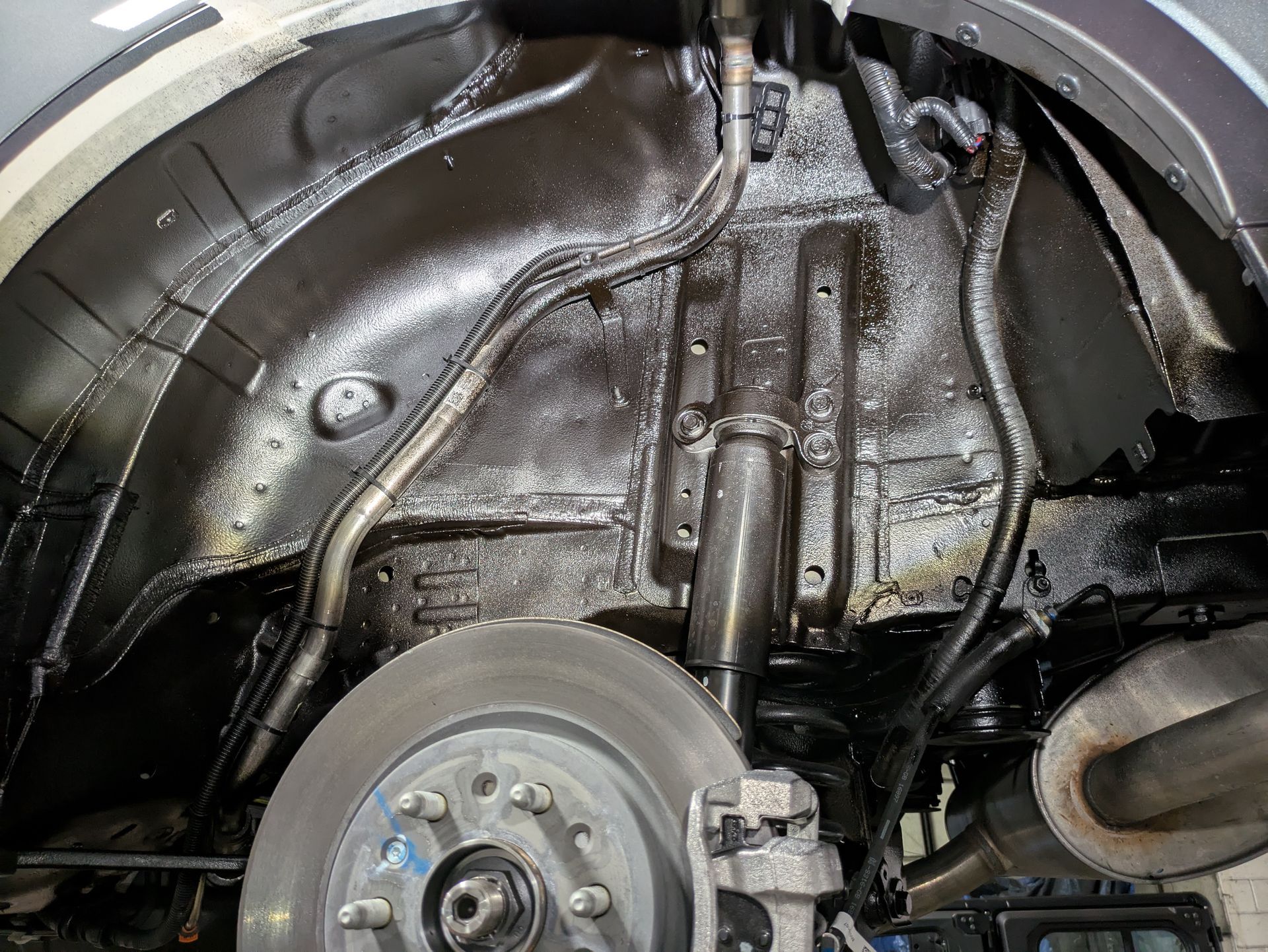 A close up of the underside of a car with a brake disc.