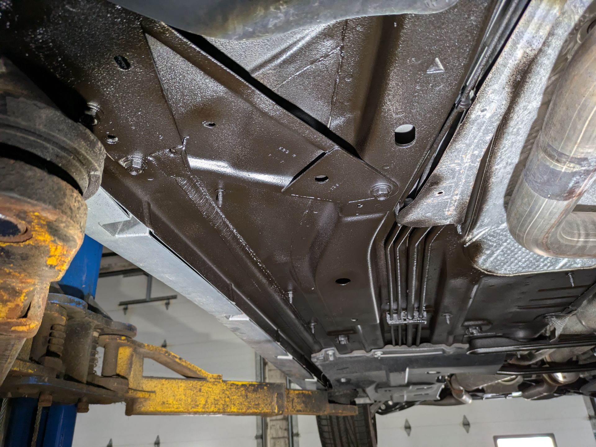 A car is sitting on a lift in a garage.