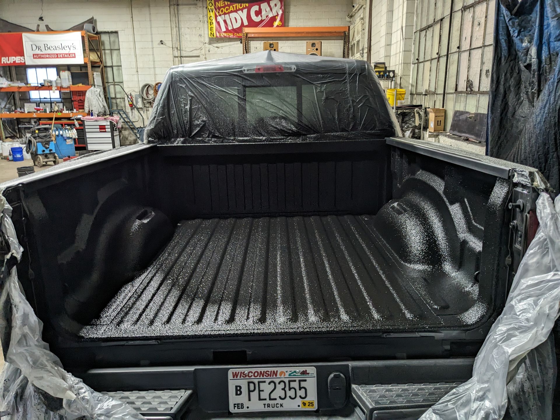 A truck with a license plate that says pe2355 is sitting in a garage.