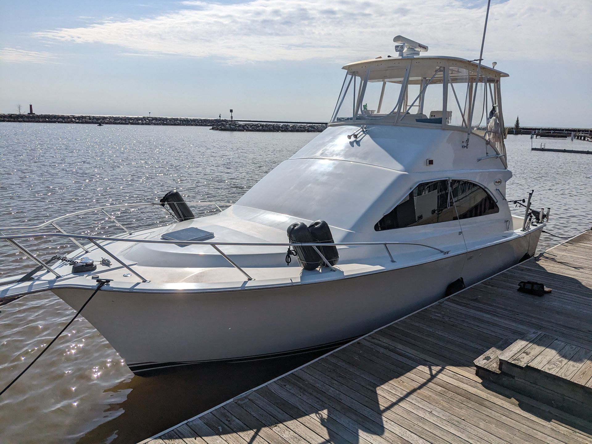 A white boat is docked at a dock in the water