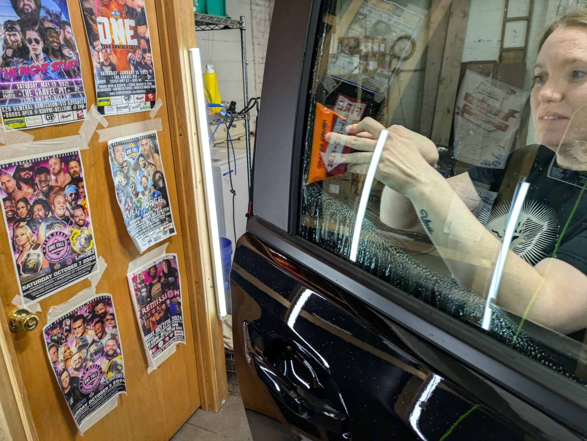 A woman is looking at her reflection in a car window.