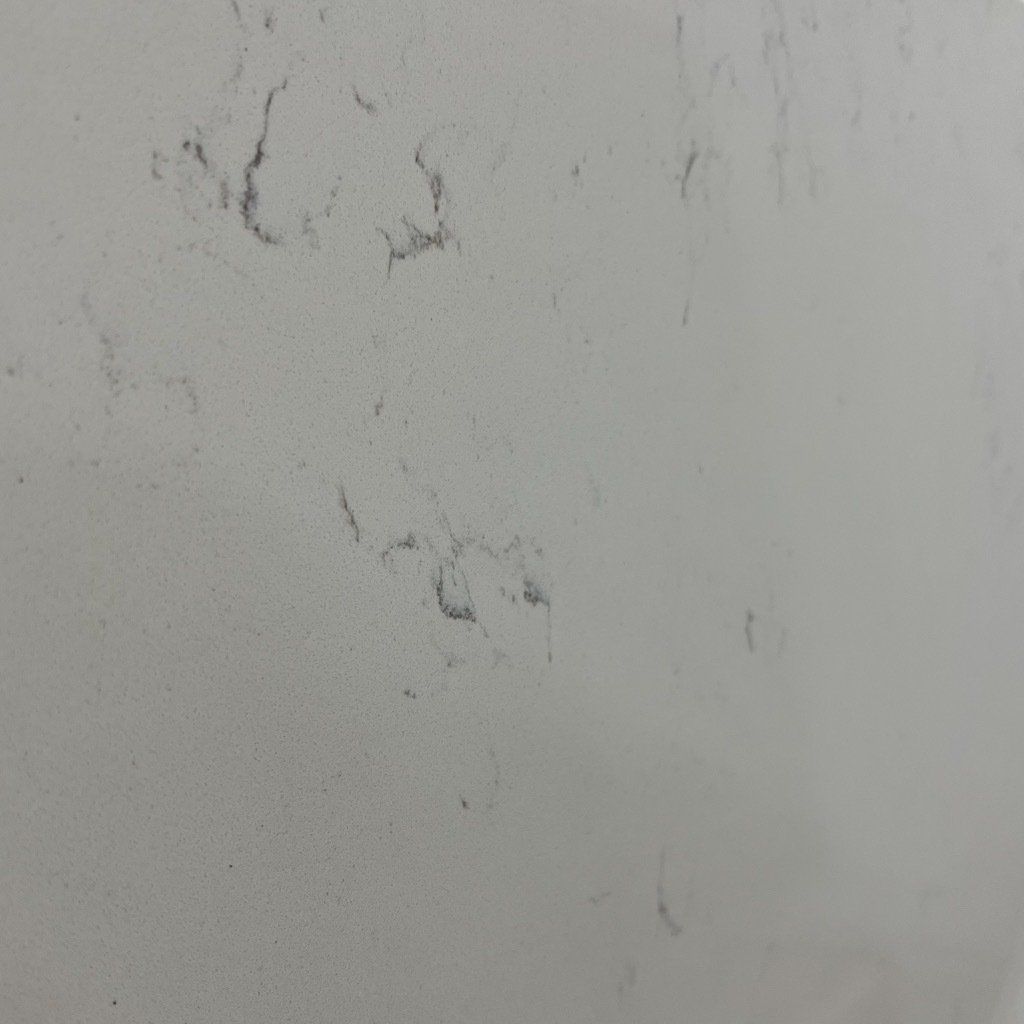 A close up of a white surface with black spots on it.