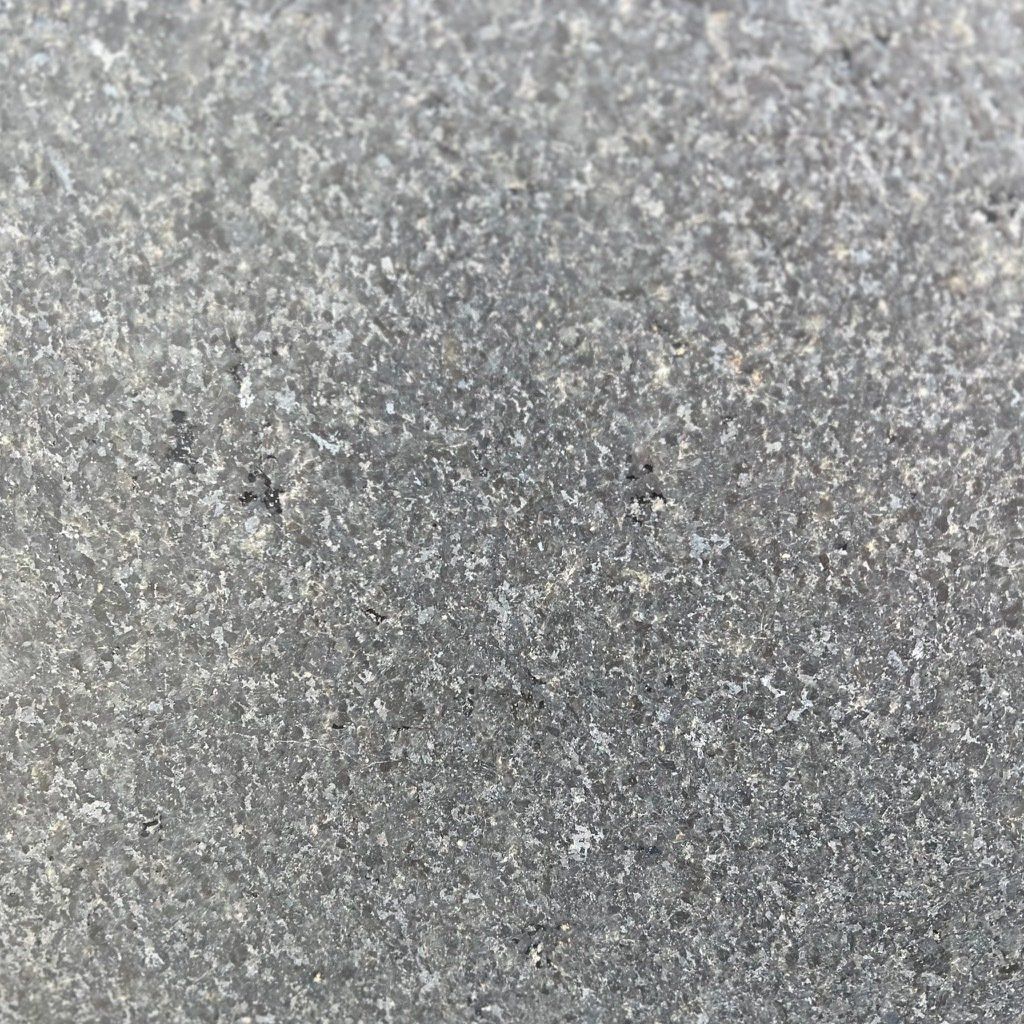 A close up of a gray surface with a lot of small stones on it.
