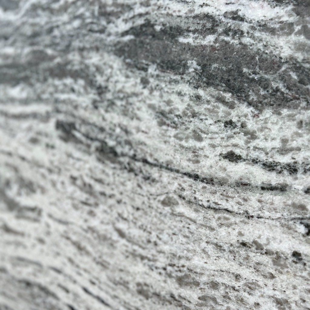 A close up of a black and white granite counter top.