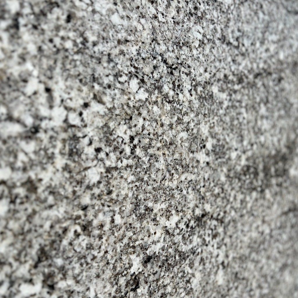 A close up of a gray and white granite counter top.