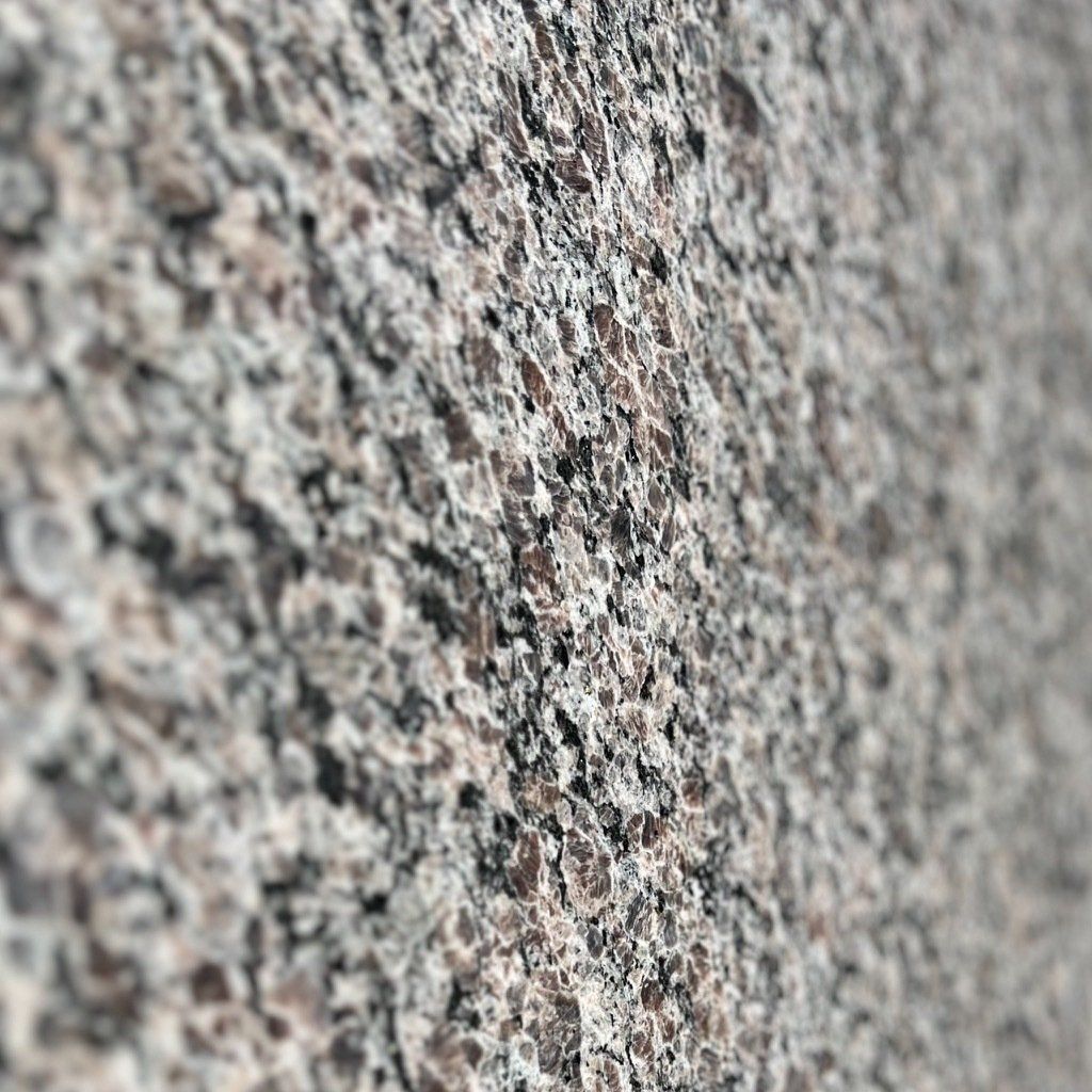 A close up of a granite wall with a lot of small stones on it.