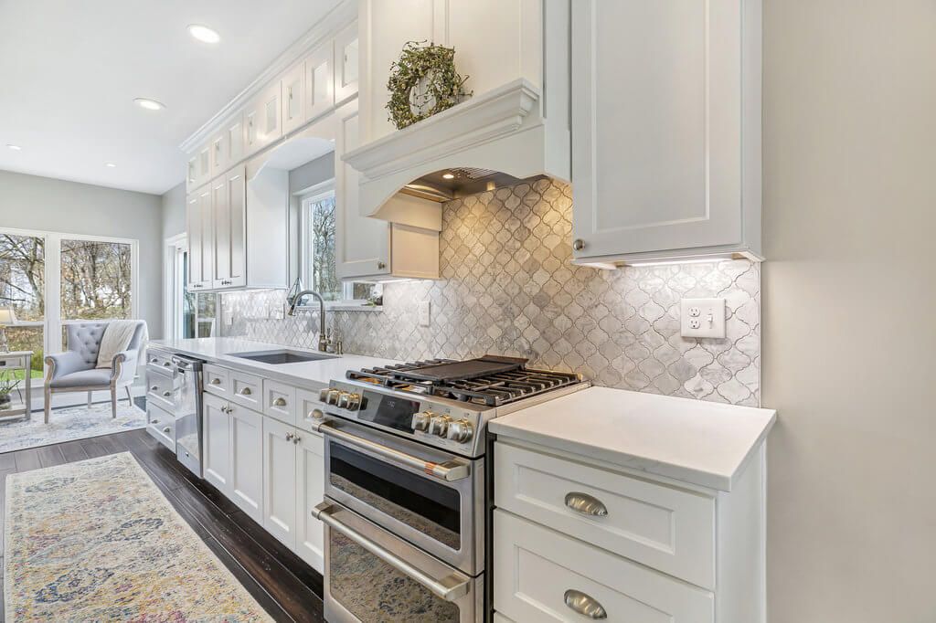 A kitchen with white cabinets and stainless steel appliances.