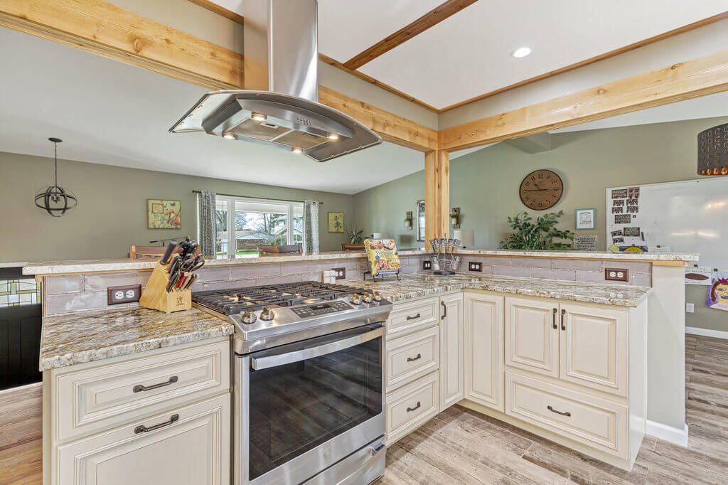 A kitchen with stainless steel appliances , granite counter tops , and white cabinets.