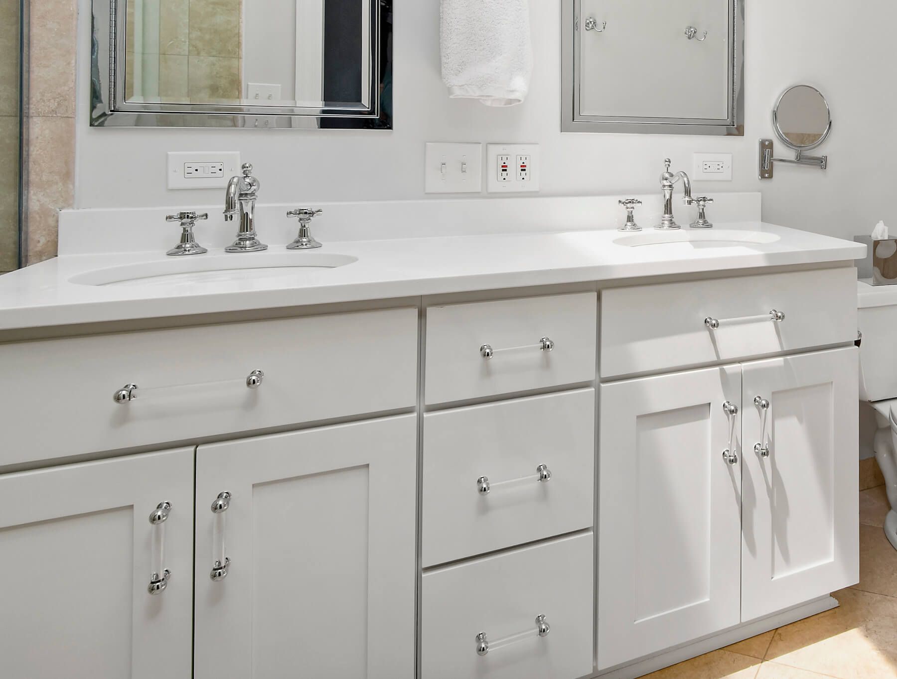 A bathroom with two sinks , a toilet and a mirror.