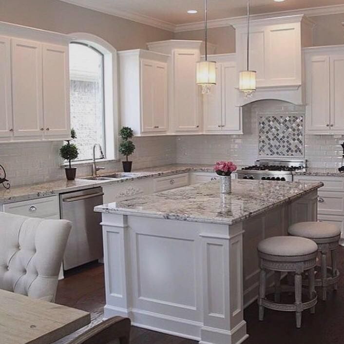 A kitchen with white cabinets and granite counter tops