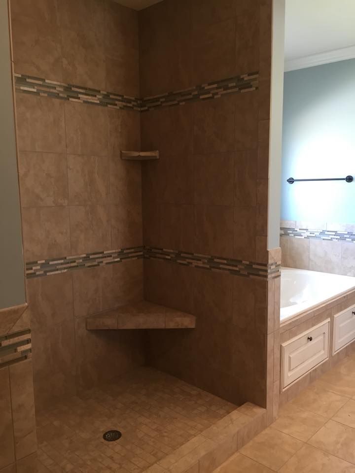 A bathroom with a walk in shower and a bathtub.