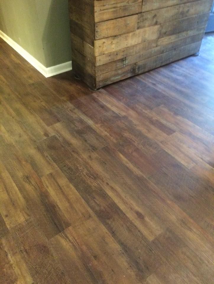 A wooden dresser is sitting on a wooden floor next to a wooden wall.