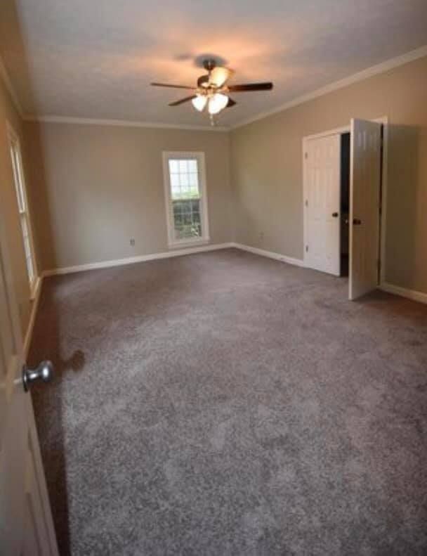 An empty room with a ceiling fan and a window