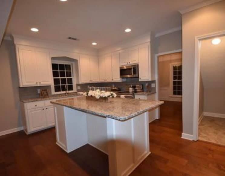 A kitchen with white cabinets and granite counter tops