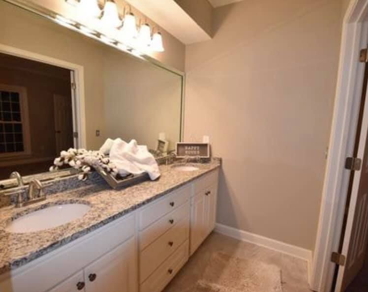 A bathroom with two sinks and a large mirror