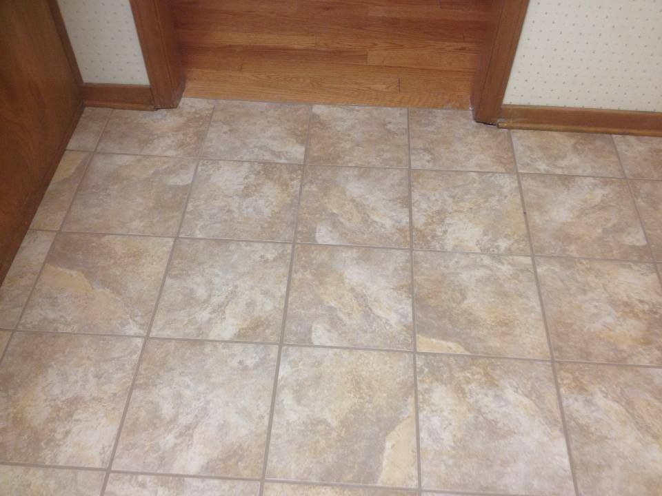 A tiled floor with a wooden door in the background