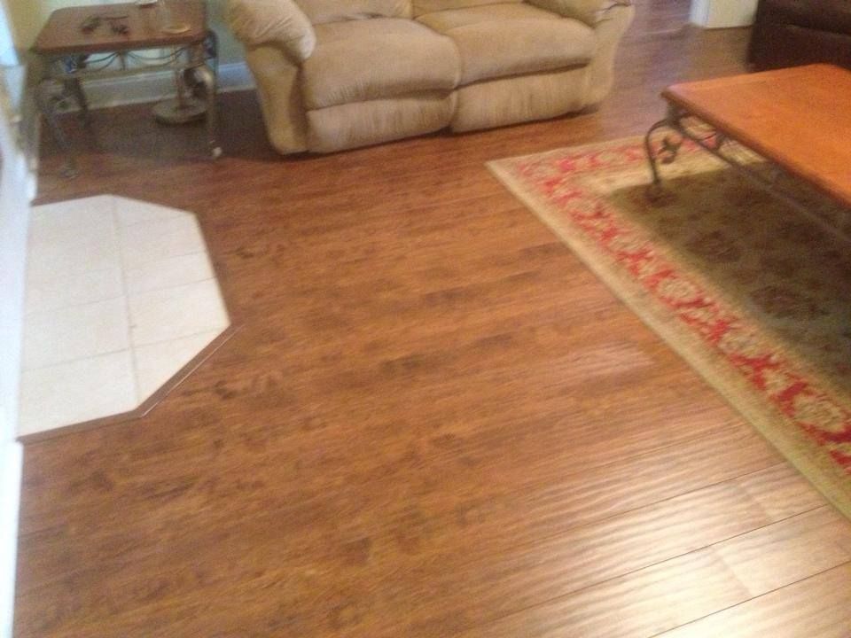A living room with hardwood floors , a couch , chair , coffee table and rug.