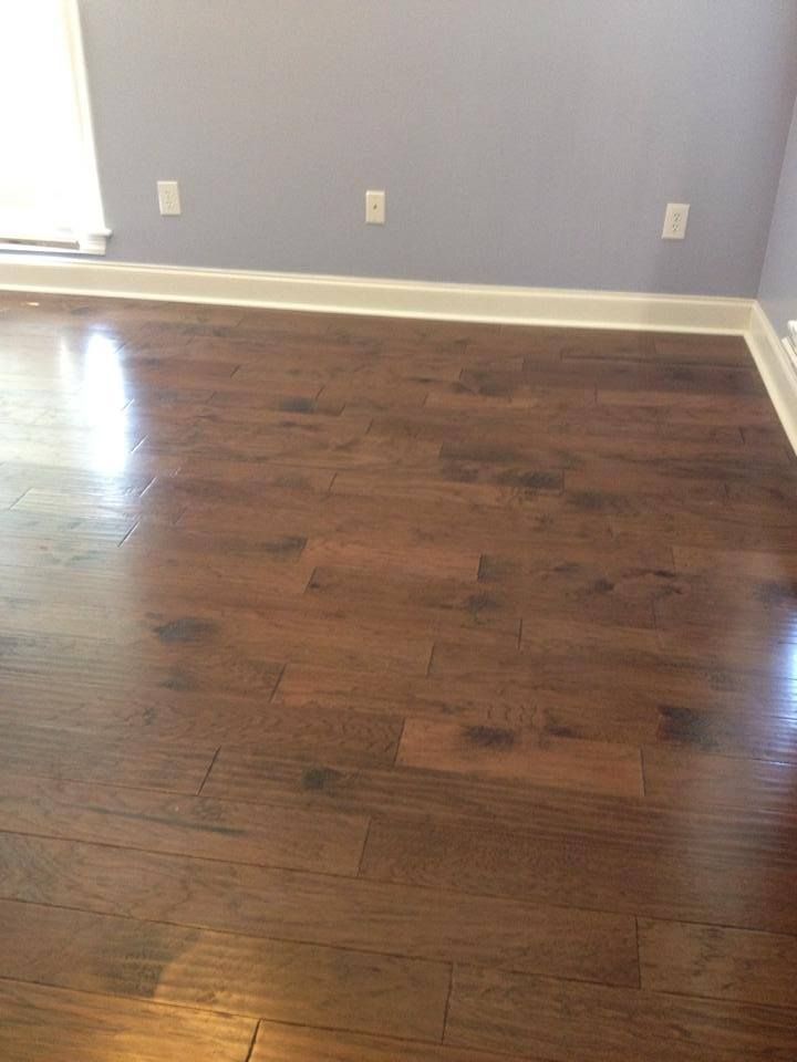 A living room with hardwood floors and a window.
