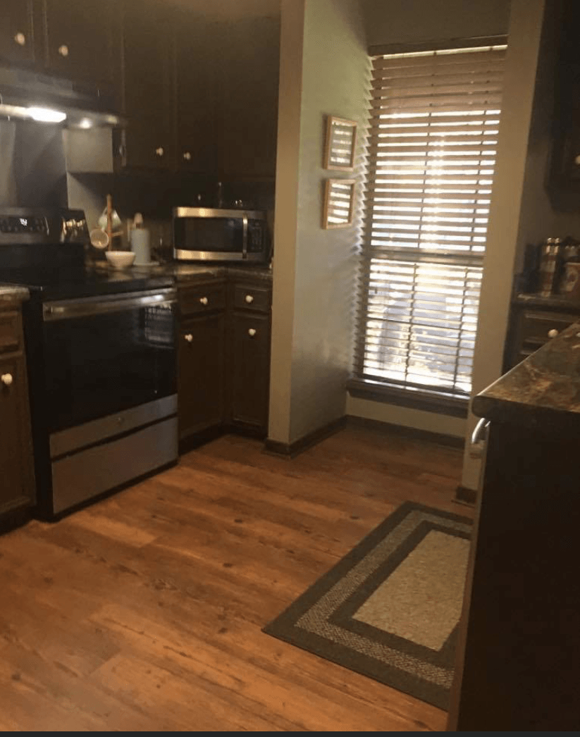 A kitchen with stainless steel appliances and wooden floors