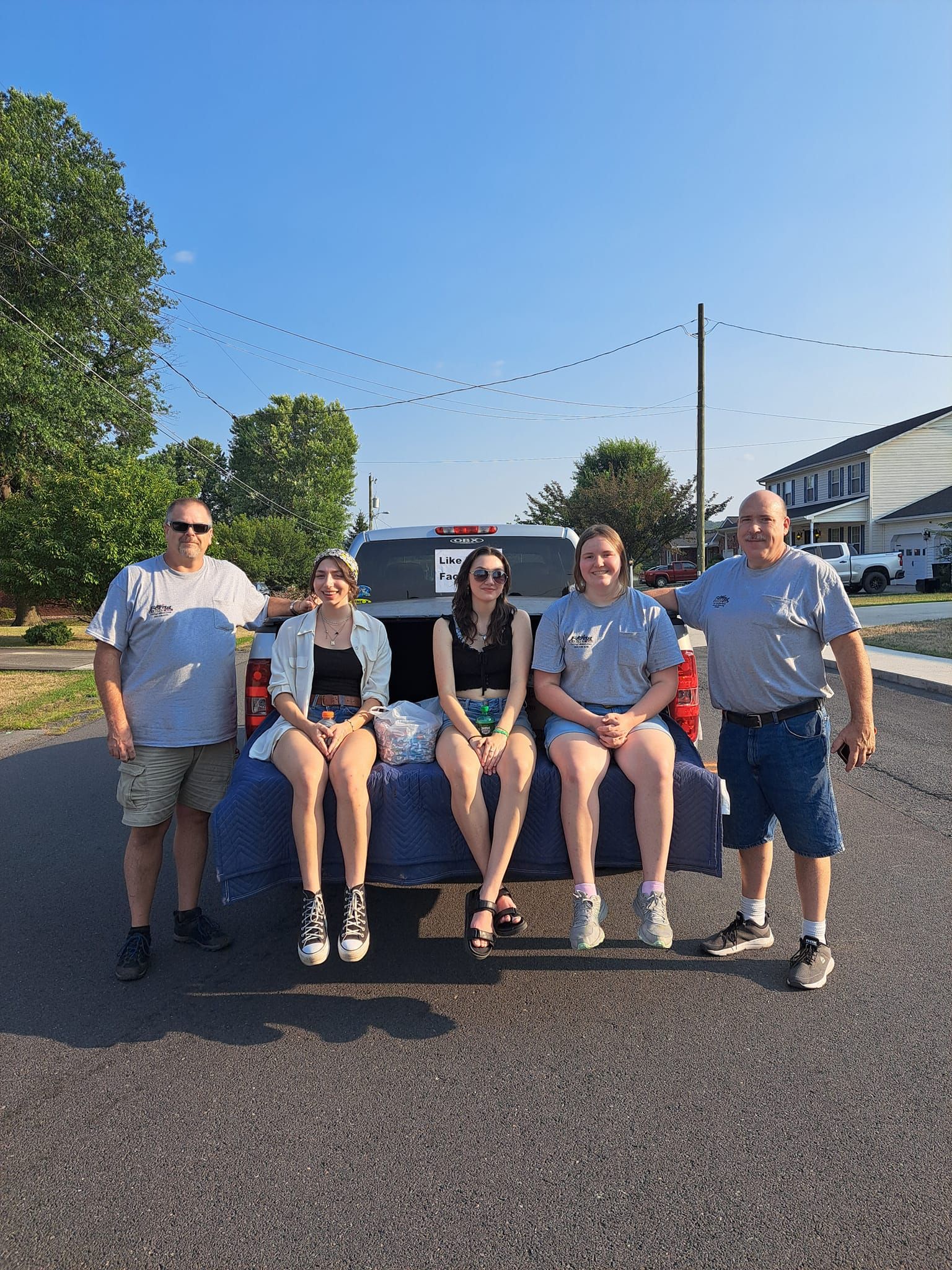 A group of people are sitting in the back of a truck.