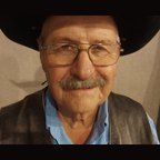 An older man with a mustache and glasses is wearing a cowboy hat.