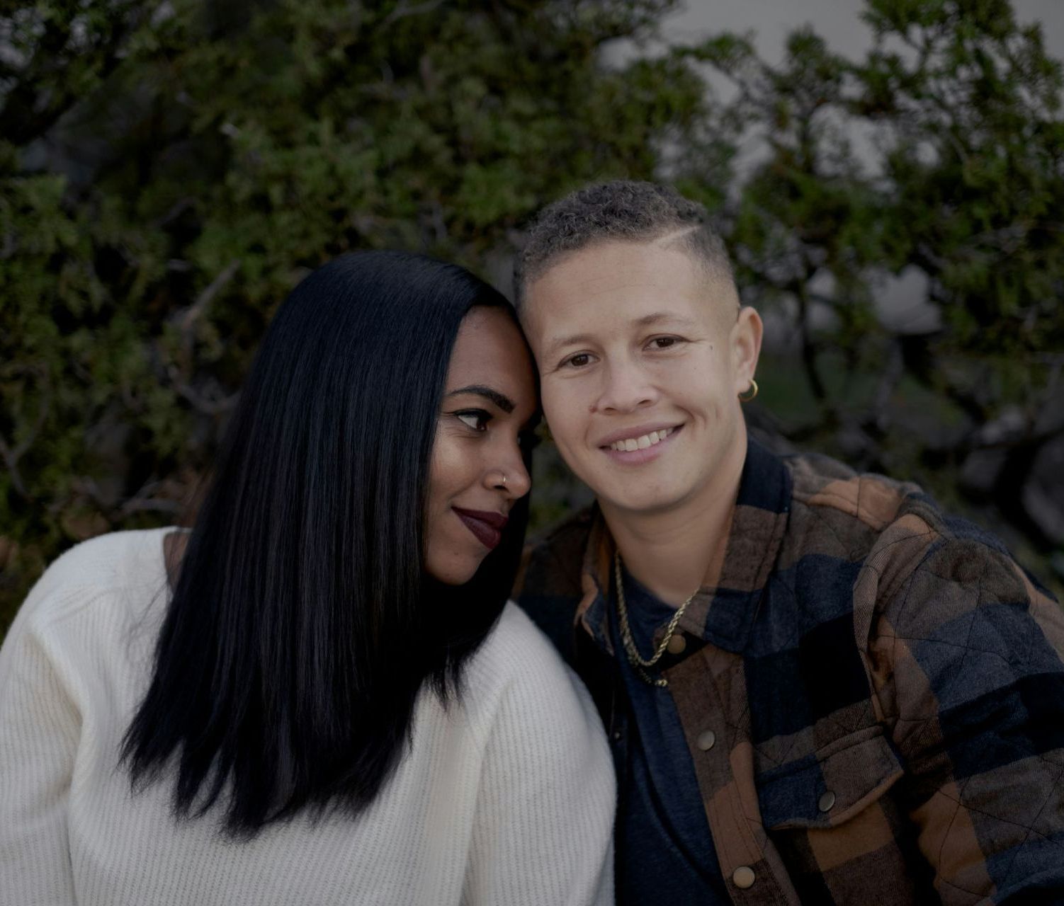 Smiling gay couple embracing outdoors, symbolizing joy, trust, and emotional connection supported through Sacramento couples therapy
