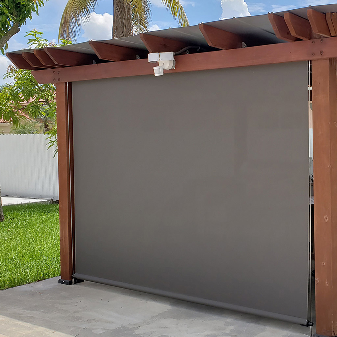 A wooden pergola with a gray screen on the side of it.