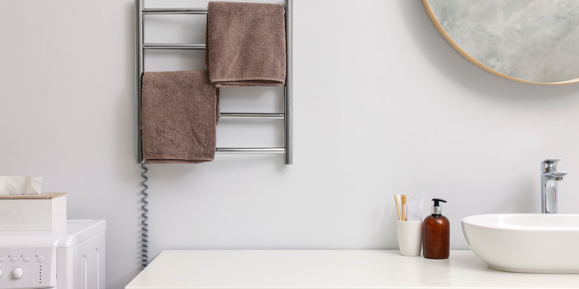 Bathroom interior: towel rack with brown towels, white sink, and minimalist decor.
