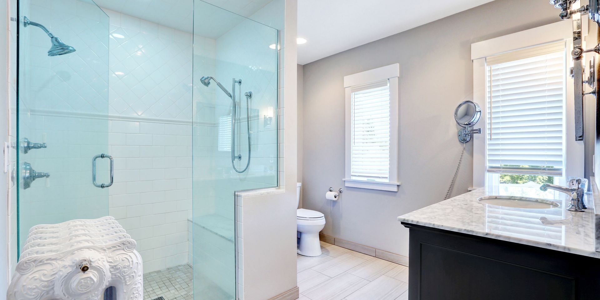 Bathroom with a glass shower and white and gray decor.