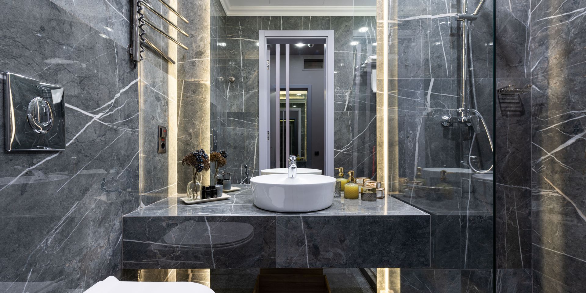 Modern gray marble bathroom with a sink, mirror, and shower.