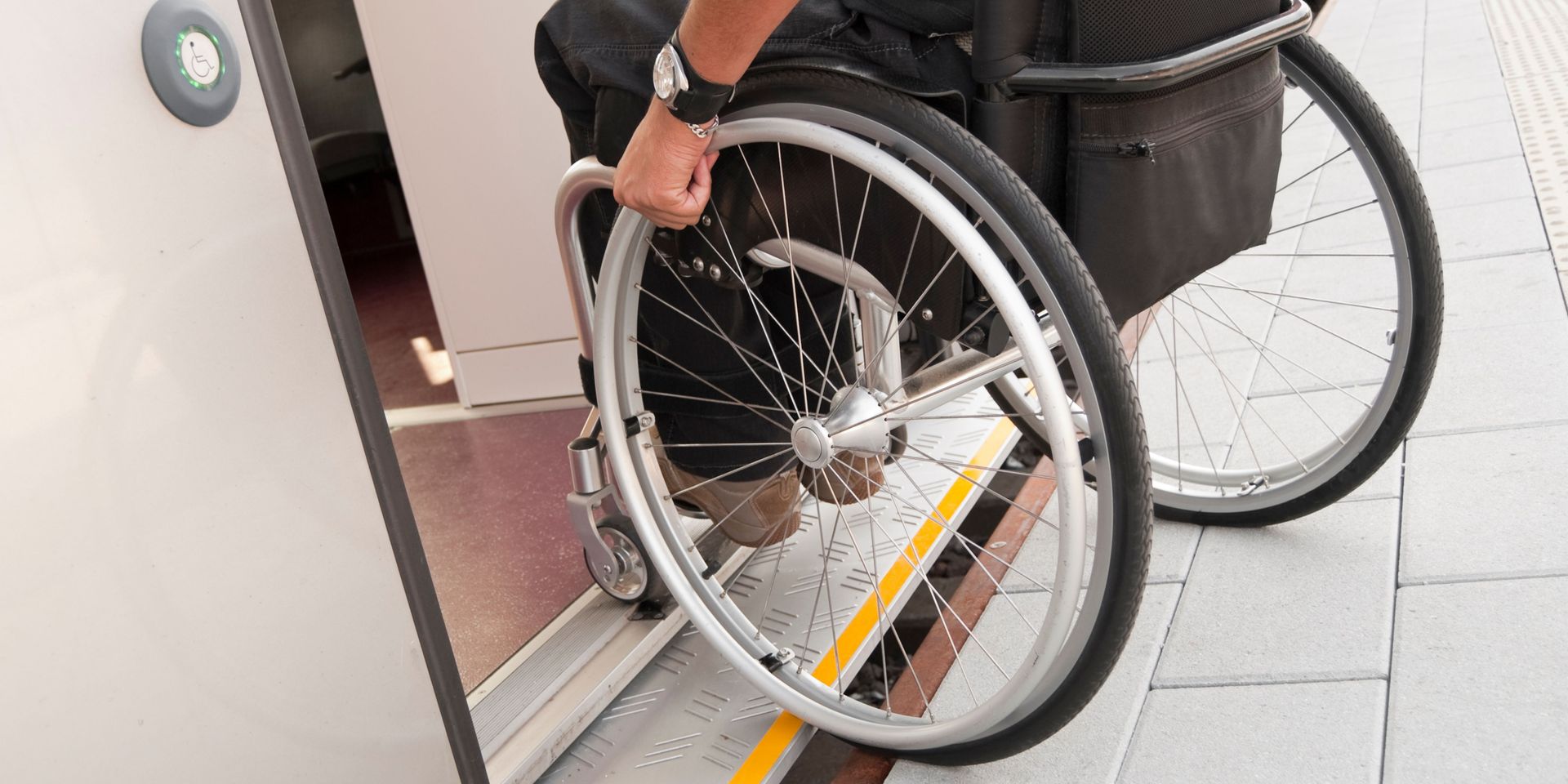 A person in a wheelchair is getting out of a door.