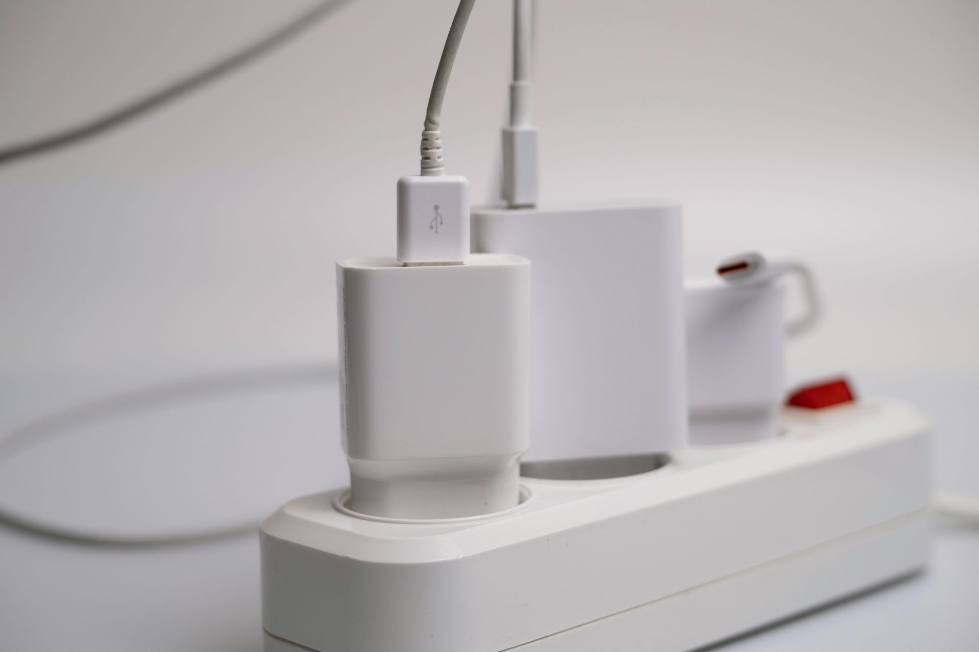 A power strip with three chargers plugged into it