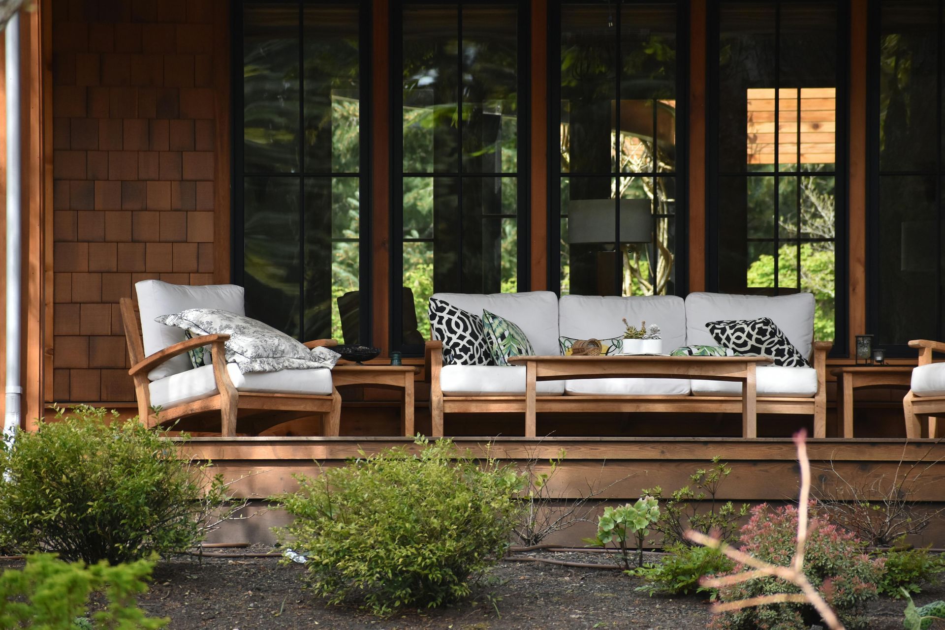 A porch with a couch and chairs on it