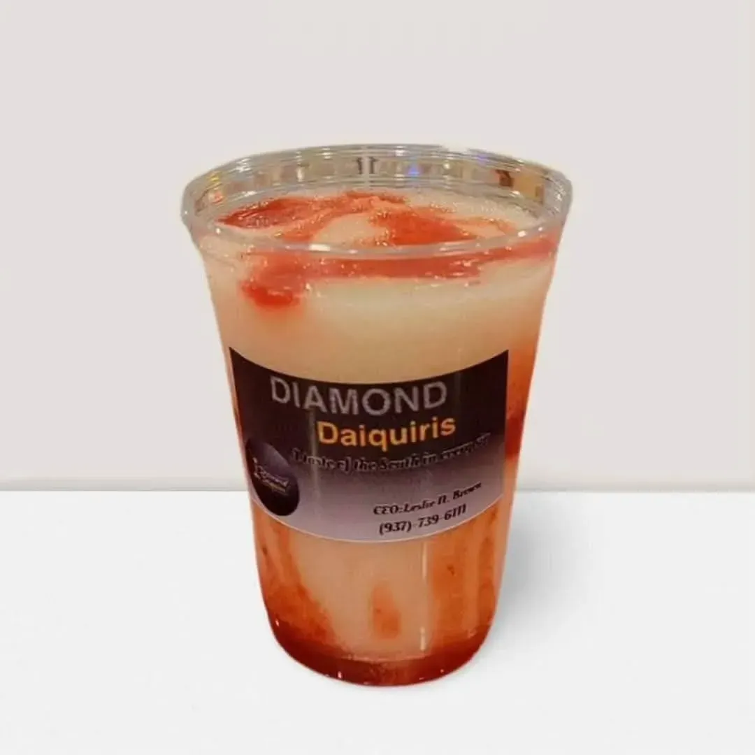 Clear plastic cup of Diamond Daiquiris, a layered peach and red frozen drink with fruit garnish