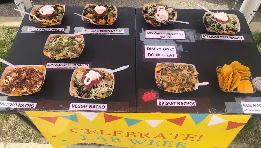 Food display on a black table with labeled dishes and a yellow sign reading “Pirate” at the front.