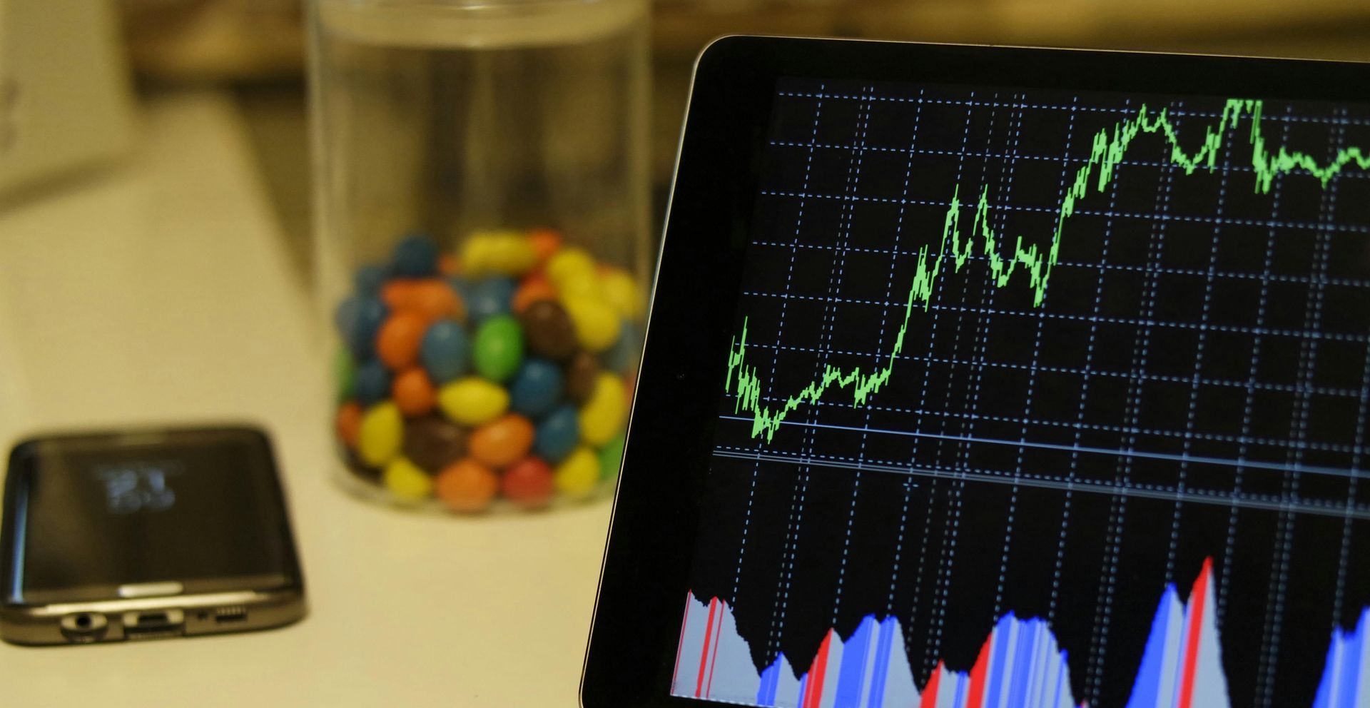 A tablet with a graph on it next to a jar of m & m 's
