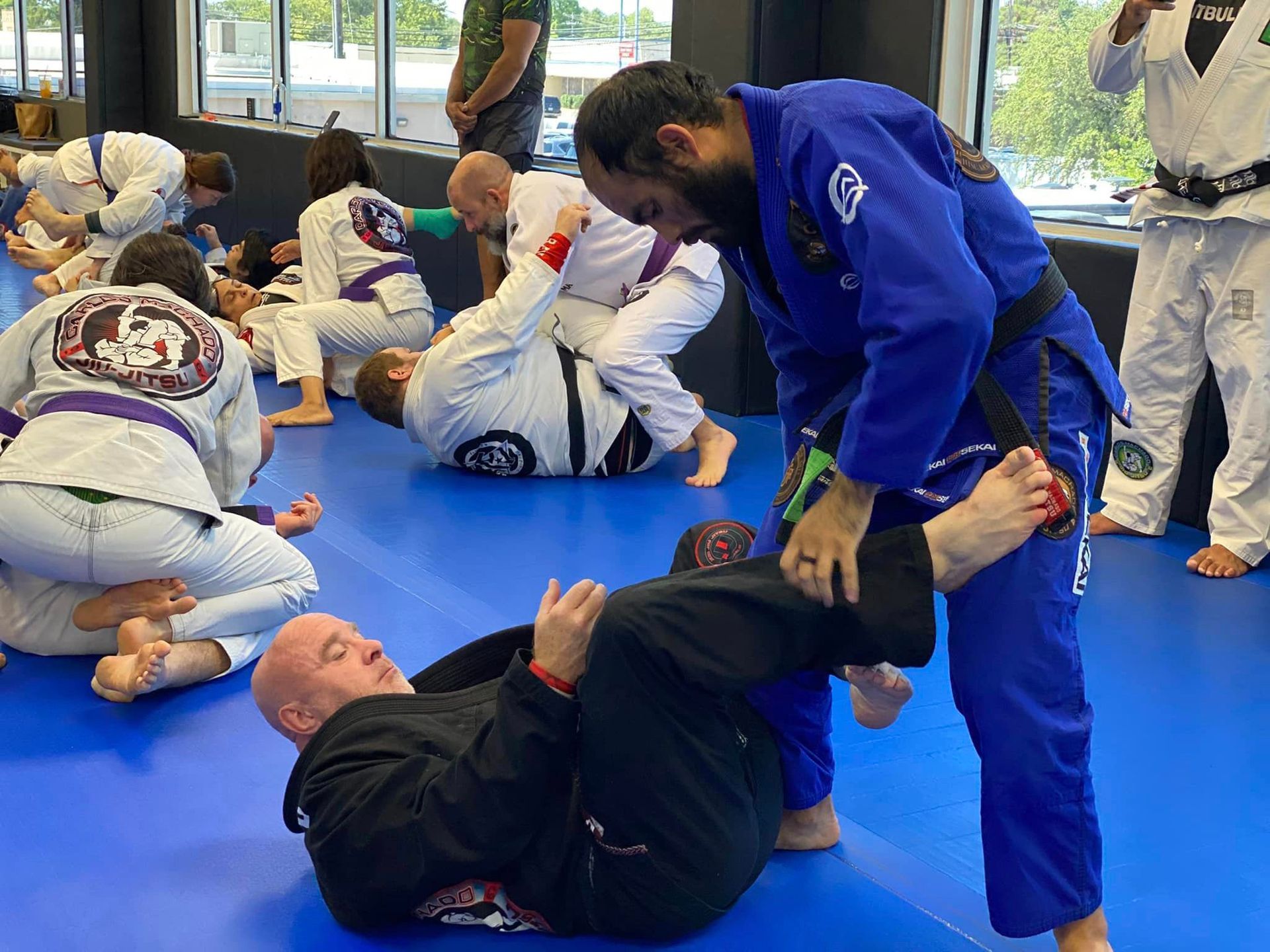 a man in a karate uniform is tying his purple belt .