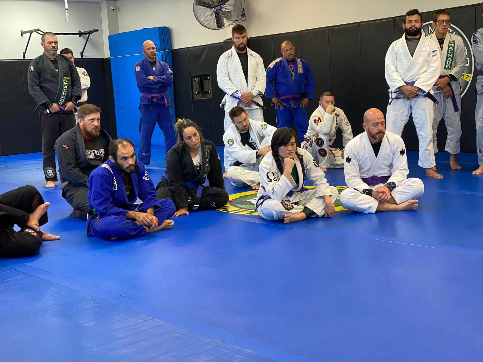 two men in blue and white kimonos are wrestling on a mat