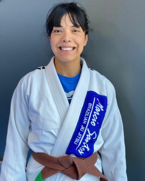 a woman is wearing a white kimono with a purple patch that says mario santos on it