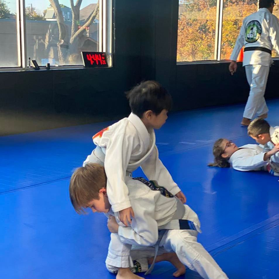 a group of young boys are practicing martial arts on a blue mat .